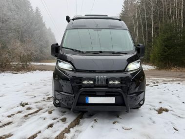 Fiat Ducato im Winter mit Frontbügel und HELLA Zusatzscheinwerfern – Frontansicht im Schnee