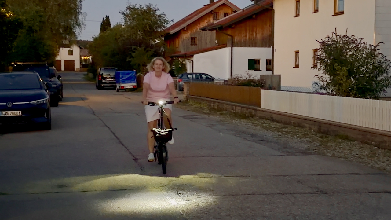 Engwe Zip Faltrad E-Bike – Nachtfahrt frontal Engwe Zip Falt-E-Bike bei Nachtfahrt auf Dorfstraße – Frontlicht beleuchtet Fahrbahn