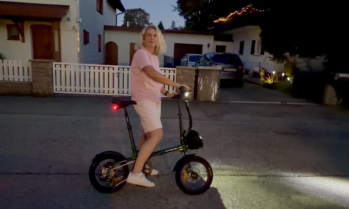 Engwe Zip Falt-E-Bike in der Dämmerung – Person steht entspannt daneben