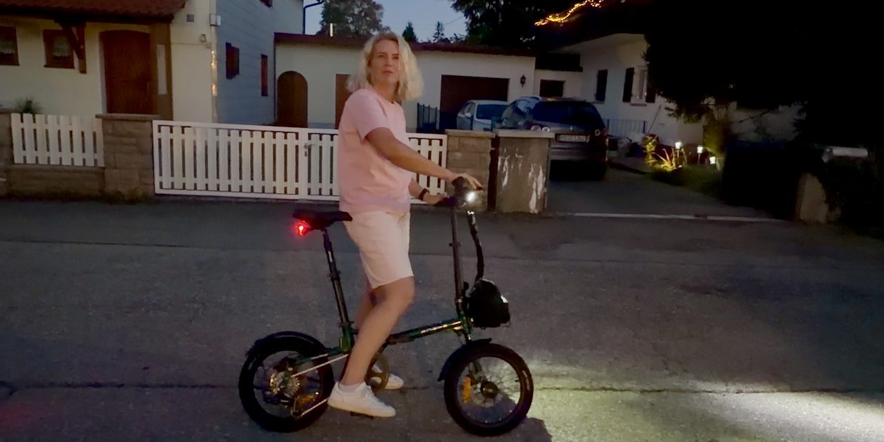 Engwe Zip Faltrad E-Bike – Lifestyle Dämmerung Engwe Zip Falt-E-Bike in der Dämmerung – Person steht entspannt daneben
