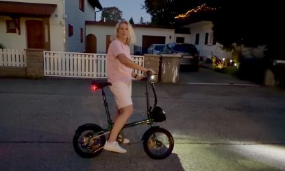 Engwe Zip Falt-E-Bike in der Dämmerung – Person steht entspannt daneben