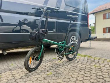 Engwe ZIP E-Faltbike neben schwarzem VW Bus Seitenansicht