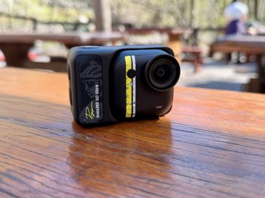 Insta360 Go Ultra mit Action Pod auf einem Outdoor-Tisch, seitliche Produktansicht zeigt Design und Aufbau