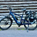 MapFour Roam blau mit Seitentasche vor rustikaler Holzwand – Touring Setup