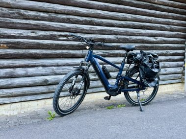 MapFour Roam blau Frontansicht LED-Licht Seitentasche vor Holzwand