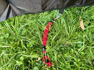 Rote Kunststoffheringe im Einsatz – your GEAR Phoenix Multicover auf Wiese